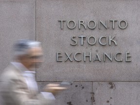 A pedestrian walks past Toronto Stock Exchange signage in Toronto’s Financial District on July 29, 2025.