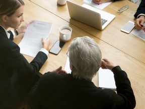 Young and senior partners team thinking talking consulting about contract sitting at conference office table.