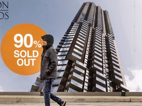 A pedestrian walks past condo real estate advertising on April 5, 2024.