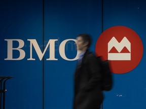 A pedestrian walks past Bank of Montreal signage on Toronto's Bloor Street West, Wednesday March 25, 2026.