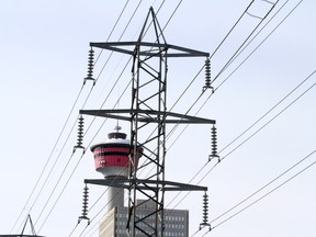 The Calgary Tower is framed by electrical power lines in Downtown Calgary.