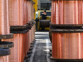 An employee works near rolls of copper wires at the Nexans manufacture in Lens, northern France, on May 11, 2022.