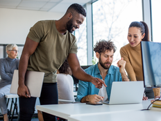 A team of creative professionals looking at the lap top and brainstorming ideas. - stock photo