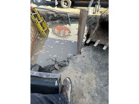 Emergency repair work following a watermain break in Hamilton, Ontario. Excavation required to access underground water service line after flooding caused by a burst pipe.