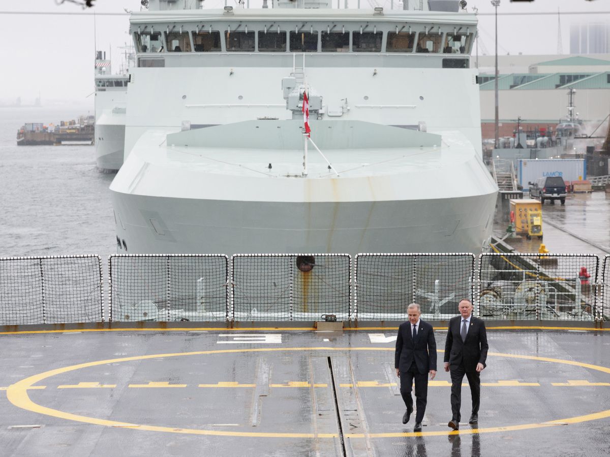  Canadian Prime Minister Mark Carney and Minister of National Defence David McGuinty, walk across the flight deck aboard HMCS Margaret Brooke during a tour and announcement aboard the ship, at HMC Dockyard in Halifax Thursday March 26, 2026.