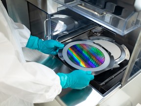 Photos of Xanadu Quantum Technologies Inc labs, as a technitian moves a plate from some electronic quipiment.