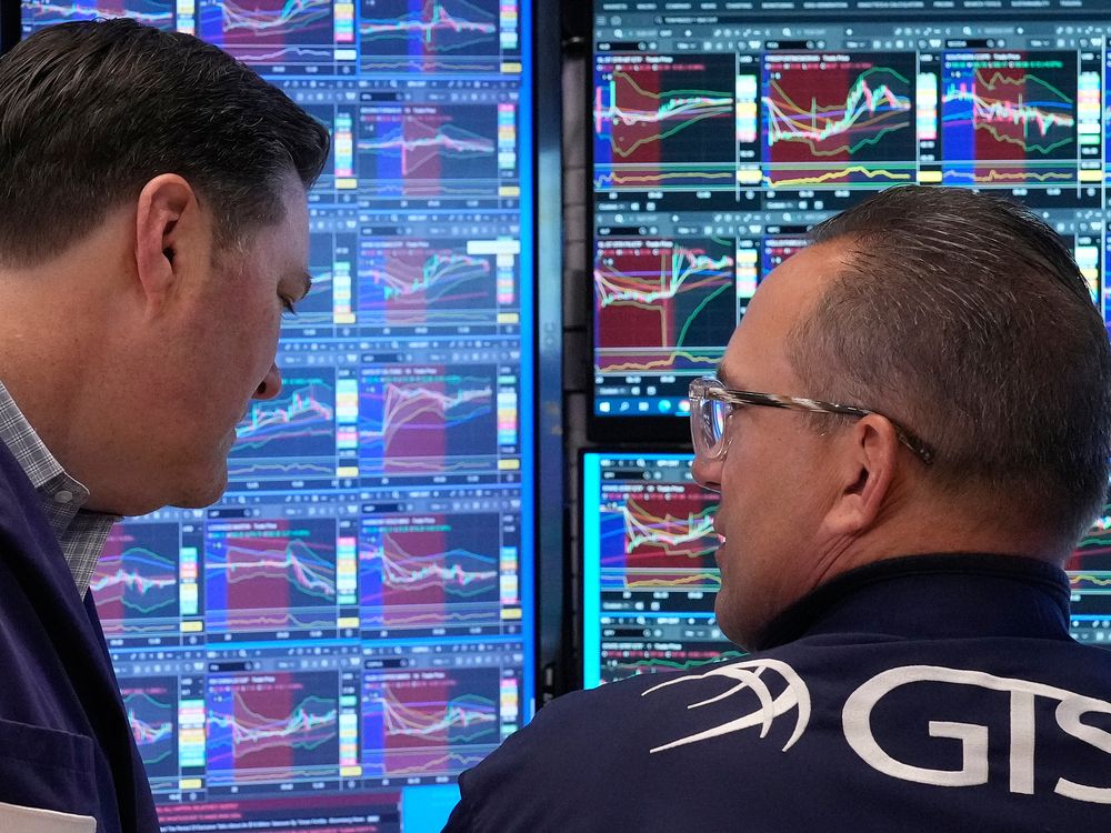 Trader Terrance McCauley, left, and specialist Anthony Matesic confer on the floor of the New York Stock Exchange on April 20, 2026.