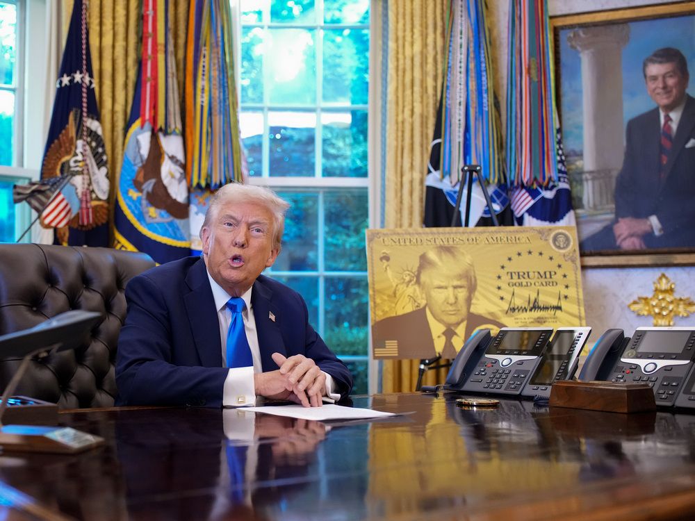 U.S. President Donald Trump, joined by Commerce Secretary Howard Lutnick (L), delivers remarks alongside a poster of the “Trump Gold Card” before signing an executive order in the Oval Office at the White House on September 19, 2025 in Washington, DC.