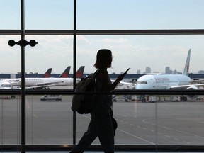 A traveller walks past Air Canada planes at Pearson International Airport in Toronto.