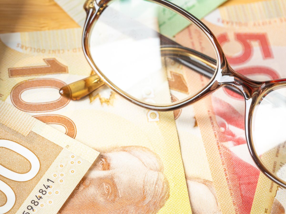 Canada money, financial analysis, company accounting, tax calculation, financial business concept. Canadian dollars together with a calculator, hand writing down the results in a notebook