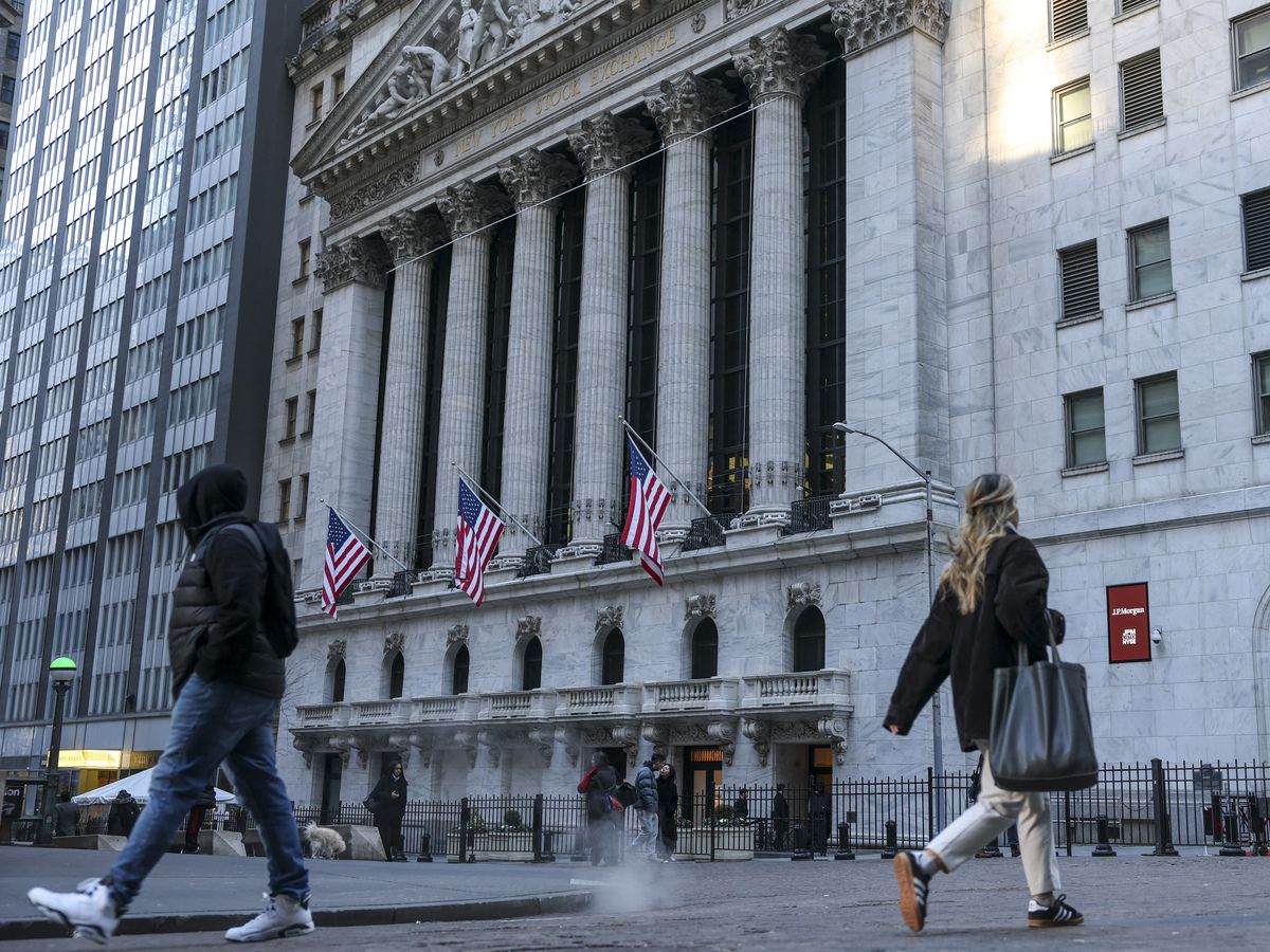 People walk past the New York Stock Exchange (NYSE) in New York on January 12, 2026.