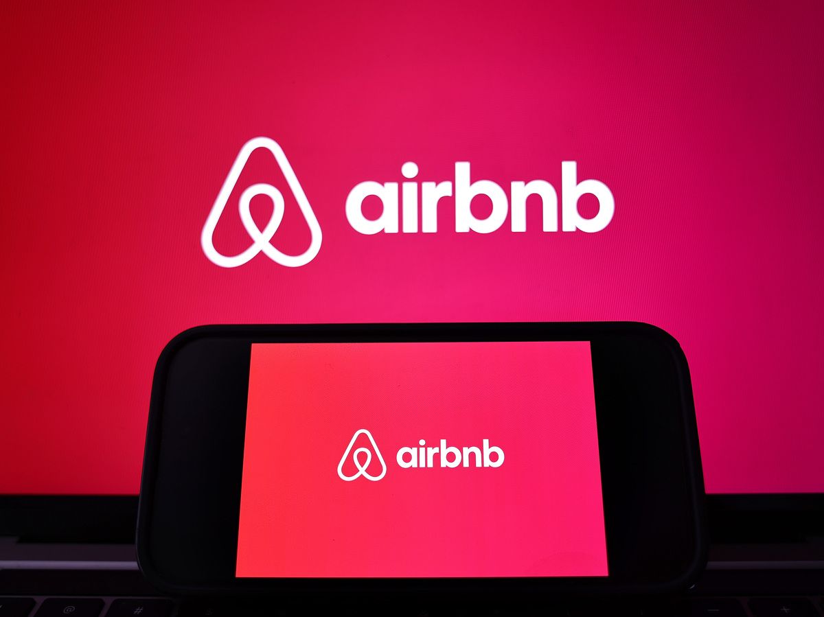 In this photo illustration, the Airbnb logo is displayed on a computer monitor and cell phone on February 13, 2024 in Los Angeles, California.