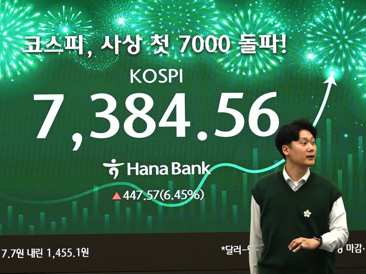A currency dealer walks past a screen showing South Korea's benchmark stock index (KOSPI) in a foreign exchange dealing room at the Hana Bank headquarters in Seoul on May 6, 2026.