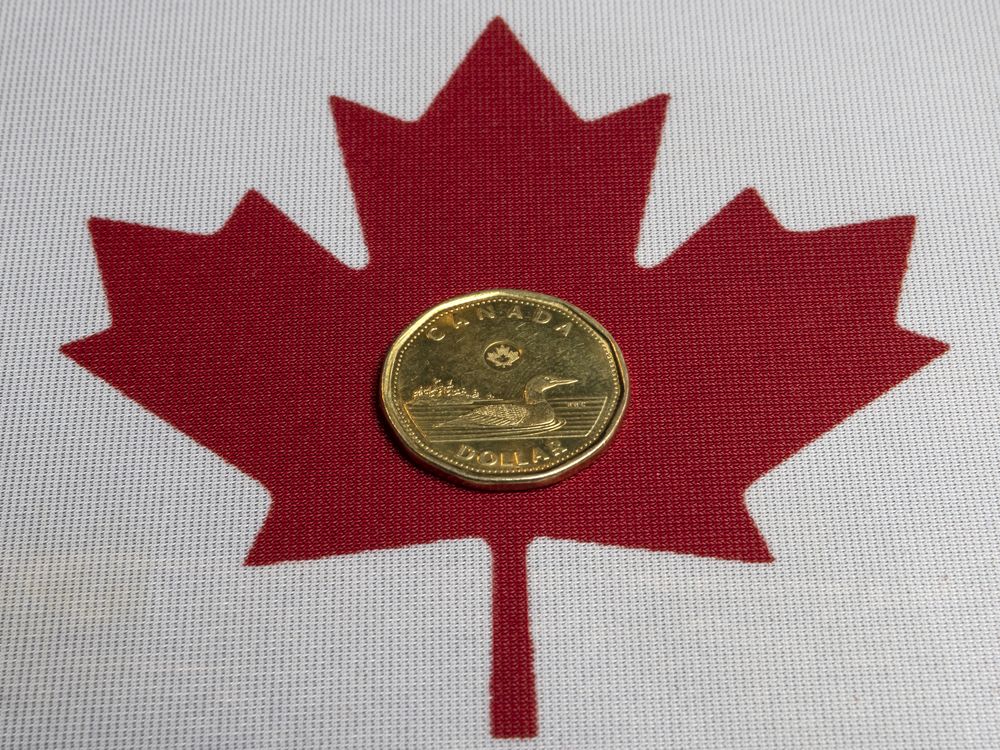 The Canadian loonie dollar and Canadian flag, Wednesday March 5, 2025.