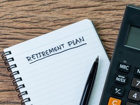 Retirement planning concept, calculator with empty notepad with pen and handwriting underline headline as Retirement Plan on wood table, plan of saving and investment for expense after retire life