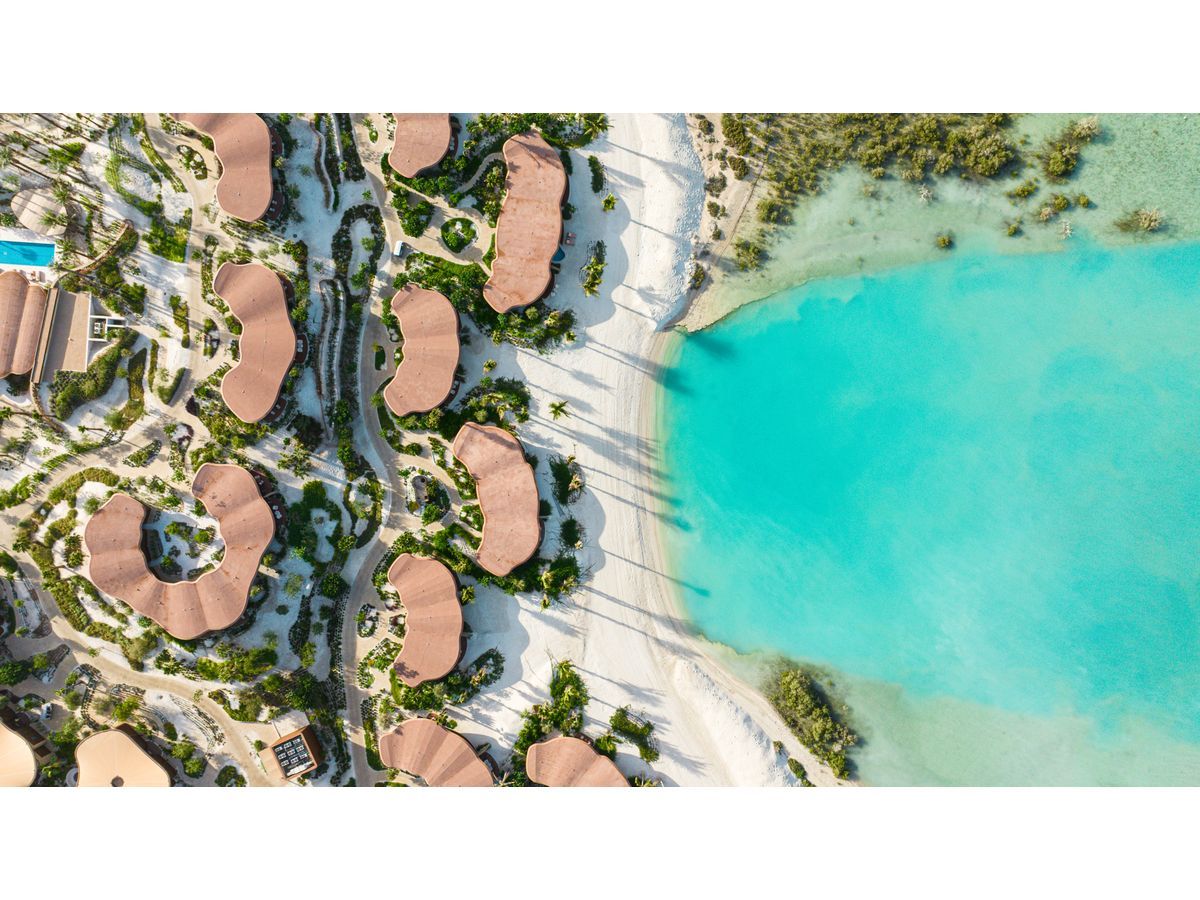 An aerial view of Four Seasons Resort and Residences at Shura Island, set along the shoreline with clear views of the Red Sea.