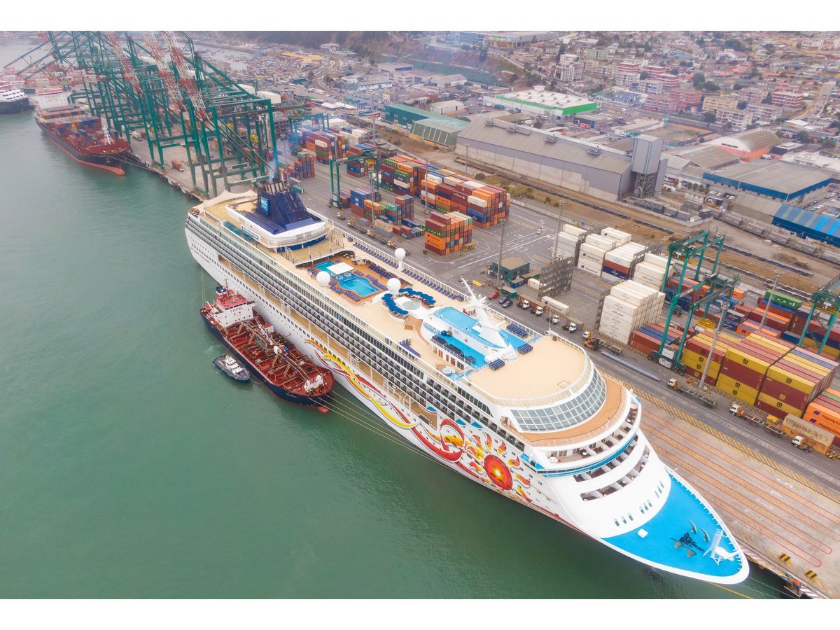 A cruise ship berths at DP World in San Antonio during the 2025–2026 season, supported by tug operations alongside container terminal activities.