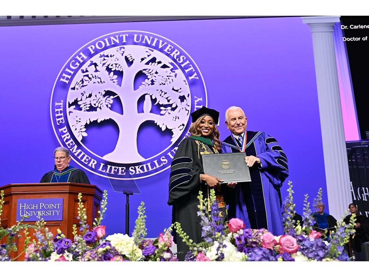High Point University honored graduate students who crossed the stage during its Commencement Ceremony for doctoral and master's students on April 30 in the Nido and Mariana Qubein Arena and Conference Center. A graduate smiled as she paused on stage for a photo with HPU President Nido Qubein.