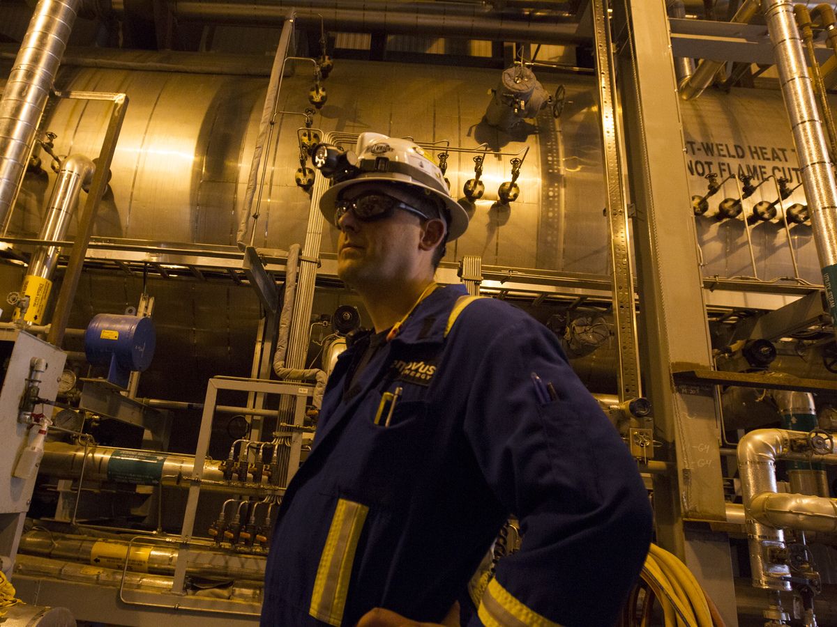 An employee stands inside an oil treatment room at Christina Lake, a situ oil production facility half owned by Cenovus Energy Inc. and ConocoPhillips Co., in Conklin, Alta.