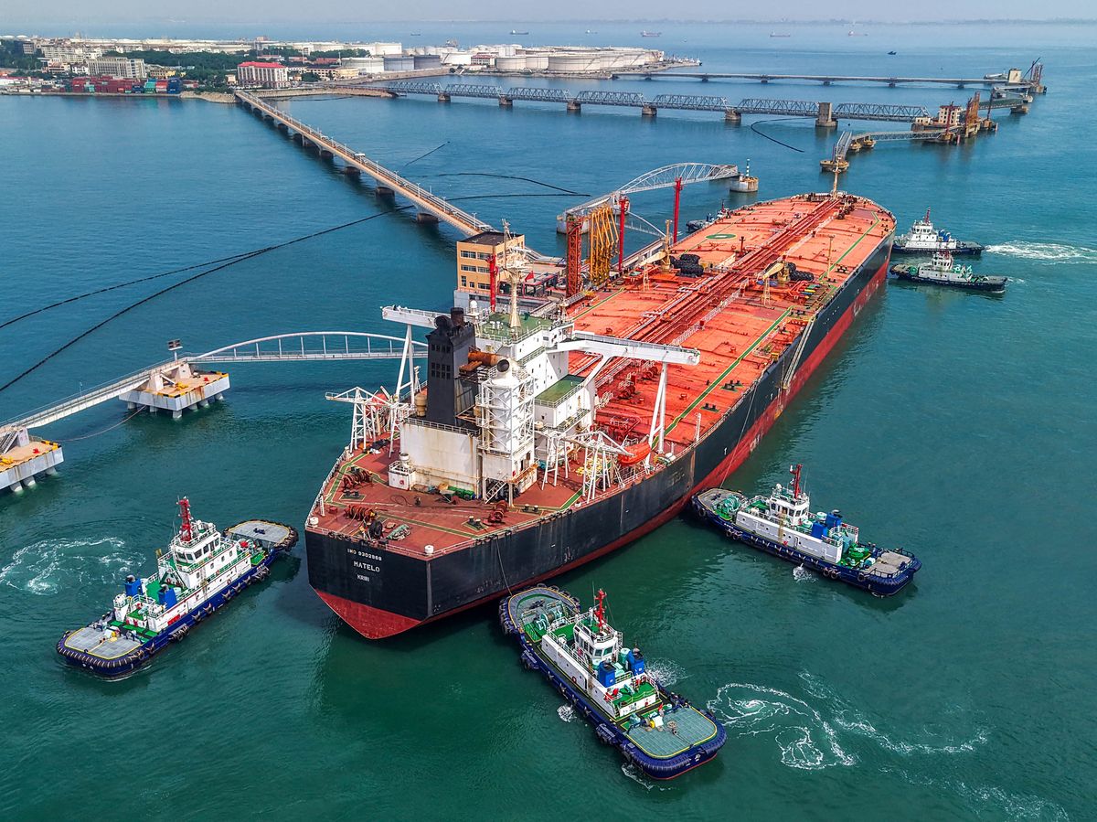Tugboats move a crude oil tanker to its berth at the oil terminal at the port in Qingdao, in China's eastern Shandong province on June 8, 2026.