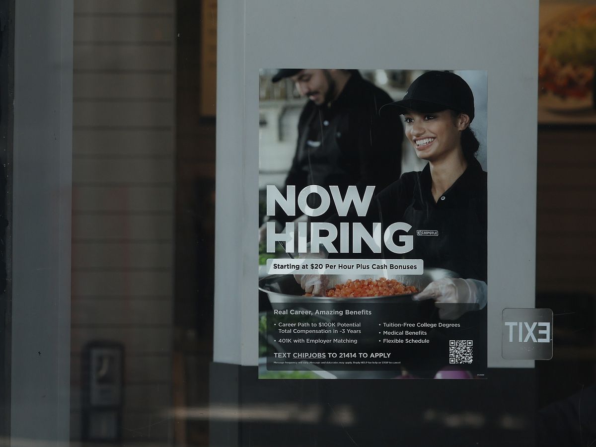 A now hiring sign is posted in the window of a Chipotle restaurant on June 05, 2026 in Los Angeles, California.