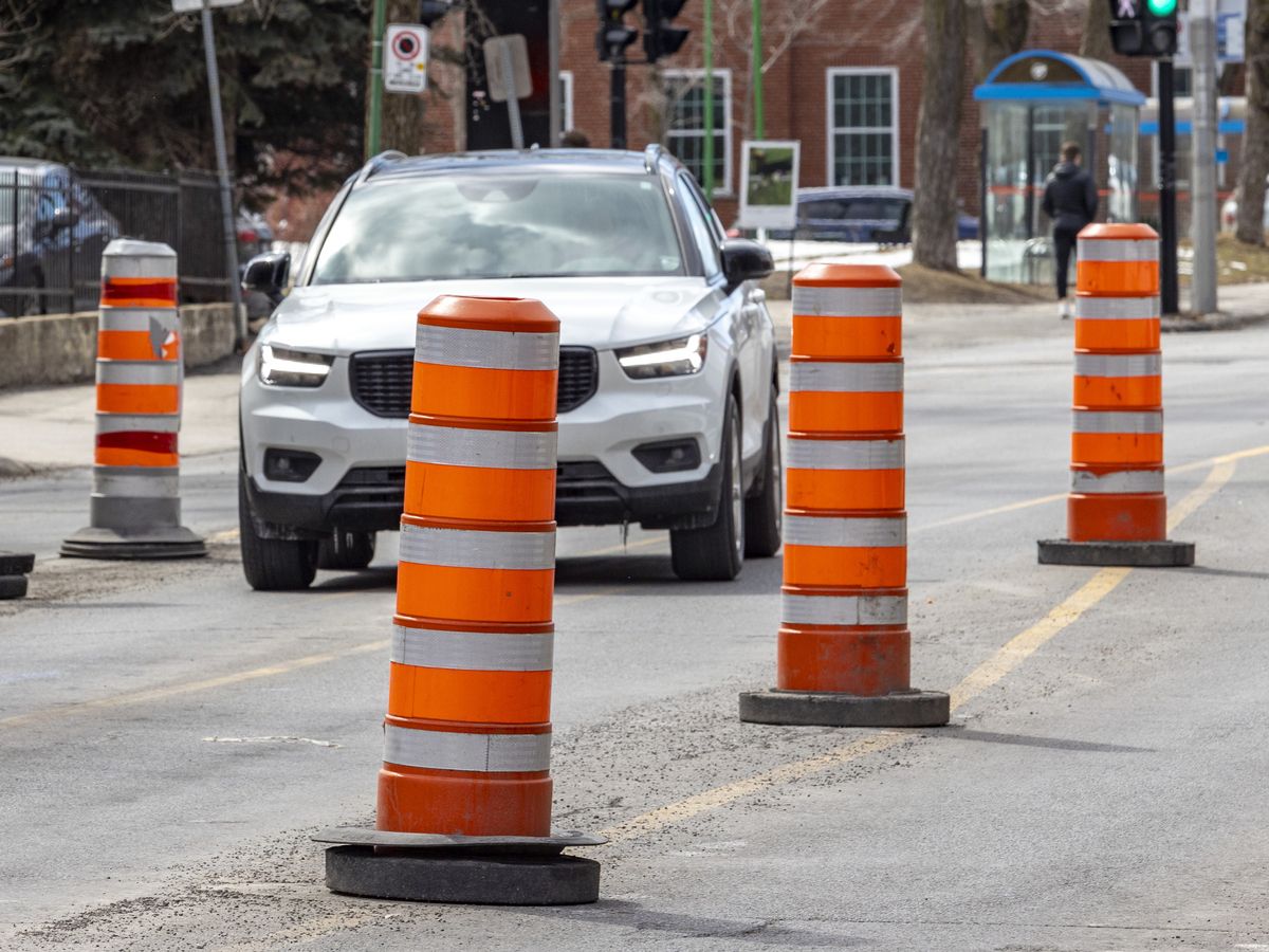 A car drives through traffic cones on Van Horne Ave. in the Outremont borough of Montreal Thursday March 30, 2023.