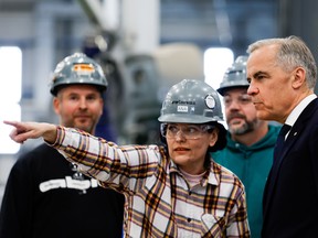 Prime Minister Mark Carney chats with three Ukrainian workers during a tour of a home manufacturing facility in Ottawa on Monday, June 1, 2026.