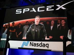 SpaceX CEO Elon Musk, displayed on a screen remotely from SpaceX headquarters in Starbase, Texas, speaks before the launch of SpaceX's initial public offering (IPO) at the Nasdaq MarketSite in New York on June 12, 2026.