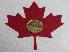 The Canadian loonie dollar and Canadian flag, Wednesday March 5, 2025.
