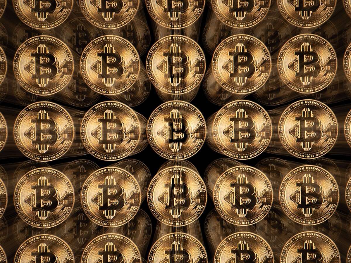 This illustration photograph shows a screen displaying Bitcoin logos, in Mulhouse on December 5, 2025.