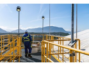 A worker on top of a refrigerated propane storage tank at an export terminal near Prince Rupert, British Columbia.