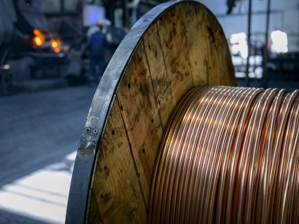 Seamless drawn smooth tubes made of copper alloys are rolled on a coil as a worker controls a furnace in the backfround at the MPG (Mendener Präzisionsrohr GmbH) tubes plant in Menden, western Germany, on June 18, 2026.