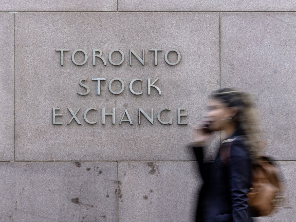 A pedestrian walks past Toronto Stock Exchange signage in Toronto’s Financial District, Tuesday July 29, 2025.