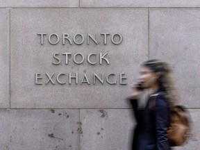 A pedestrian walks past Toronto Stock Exchange signage in Toronto’s Financial District, Tuesday July 29, 2025.