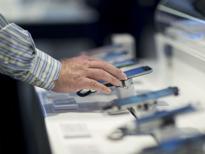 A customer browses mobile phones at a Bell Canada store in Toronto, Ontario, Canada, on Wednesday, June 22, 2016