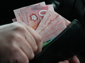 A person holds Canadian dollar banknotes, in Edmonton, Alberta, Canada, on March 26, 2025