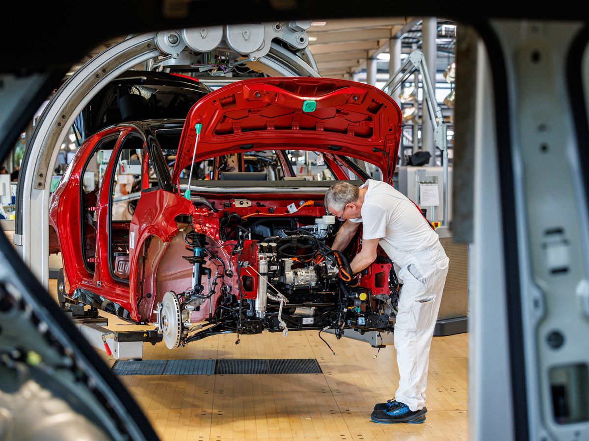An employee works on the assembly line for the Volkswagen (VW) ID.3 electric car of German carmaker Volkswagen, at the 'Transparent Factory' (Glaeserne Manufaktur) production site of German carmaker Volkswagen (VW) in Dresden, eastern Germany, on May 14, 2025