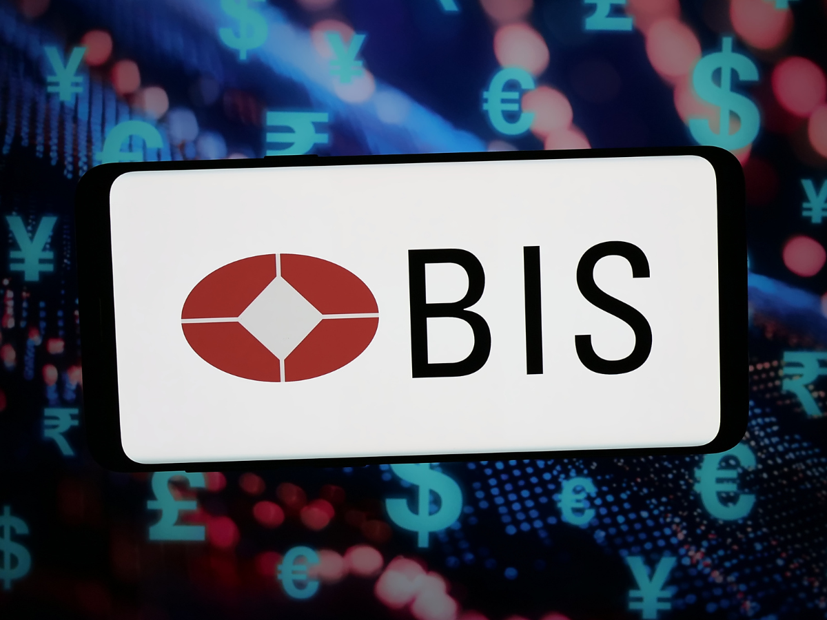 In this photo illustration, the logo of Bank for International Settlements (BIS) is displayed on a smartphone in front of abstract background on computer screen.