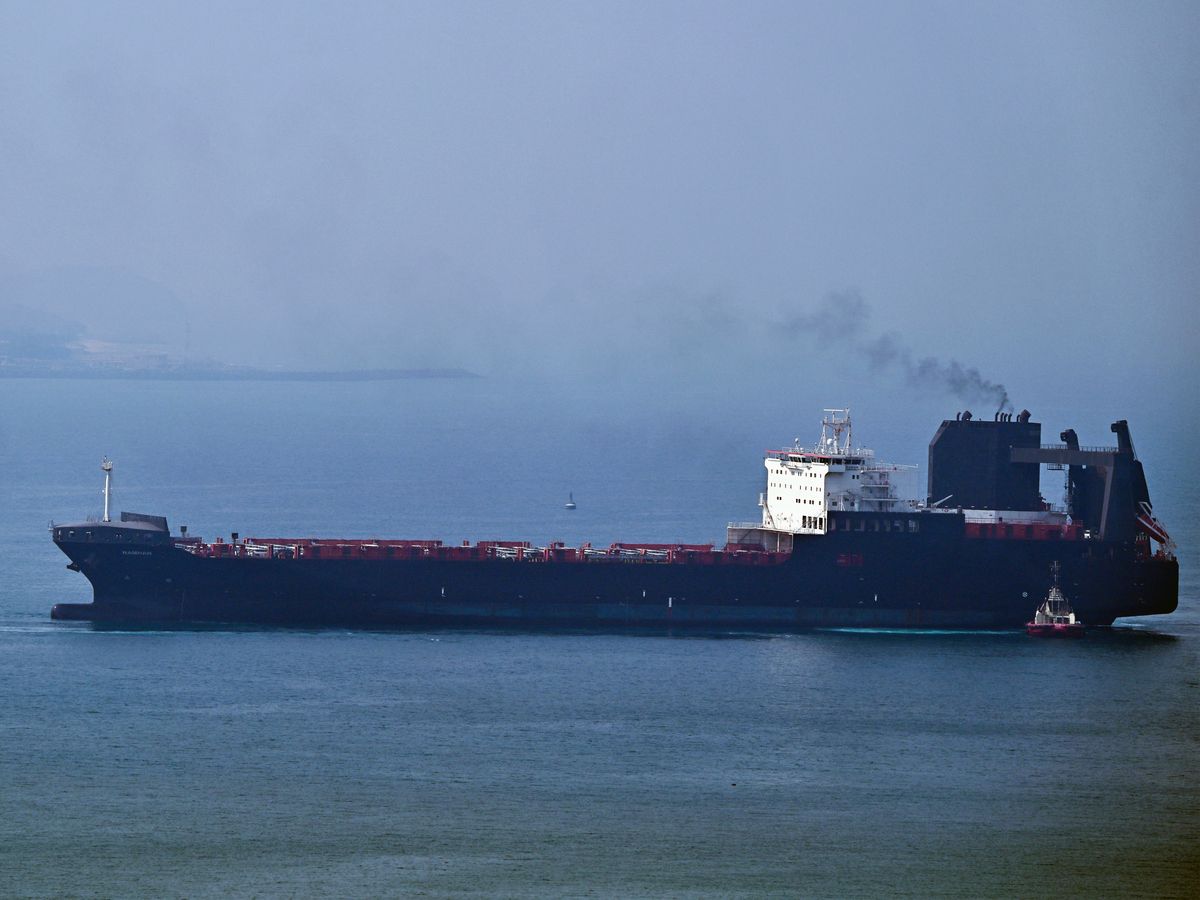 A tugboat guides a ship at the Khor Fakkan Container Terminal, the only natural deep-sea port in the region and one of the major container ports in Sharjah Emirate, along the Gulf of Oman on July 14, 2026.