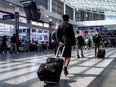 A Jazz Aviation/Air Canada flight attendant walks through the terminal at Pierre-Elliott Trudeau Airport in Montreal, Quebec, on August 19, 2025.