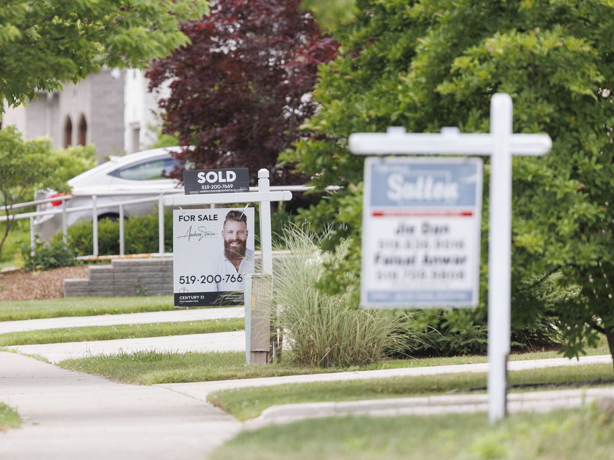 Real estate signs sit on lawns in London, Ont. on Tuesday, July 7, 2026.