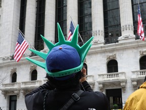 A tourist wears a Statue of Liberty-themed hat outside the New York Stock Exchange (NYSE) building in the Financial District of New York City, on April 4, 2025.