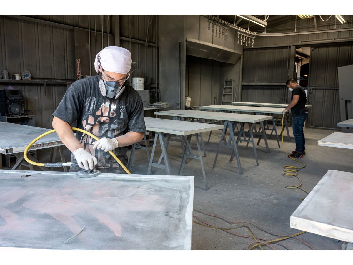 Workers sand metal doors at a manufacturing facility in Sacramento, California.