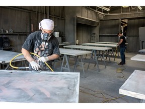 Workers sand metal doors at a manufacturing facility in Sacramento, California.