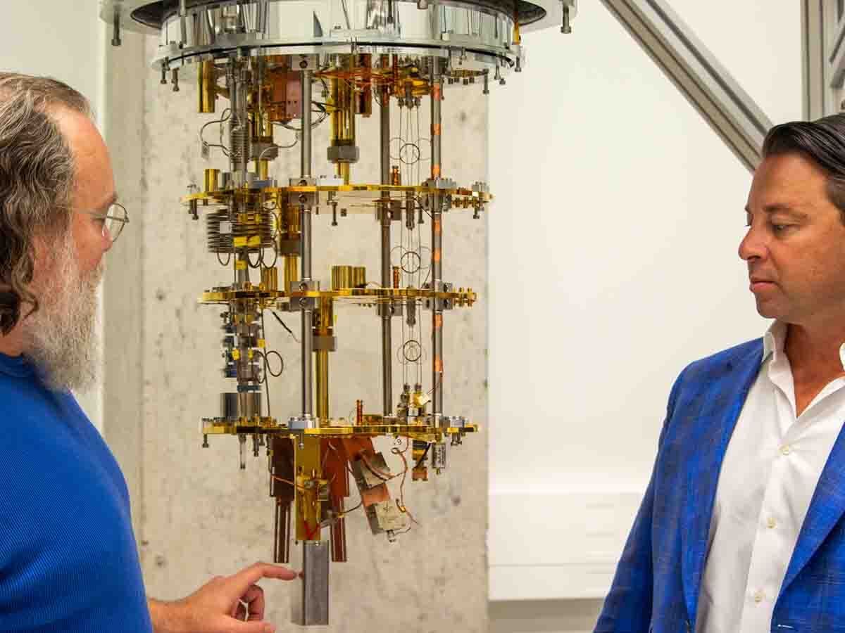 Waterloo-based QuantumCore Inc.’s chief technology officer, Christopher Wilson, points to a quantum processing unit, above which the company’s amplifier attaches, as chief executive, Eugene Profis, watches.