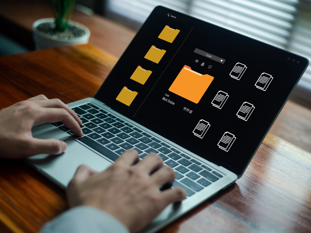 person managing digital folders and documents on a laptop, representing file organization, data storage, workflow management, and efficient document handling in a modern digital workspace.