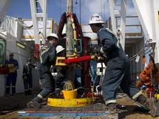 Employees torque a pipe at a wedge well in Alberta. The oil and gas sector helped drive GDP gains in May.