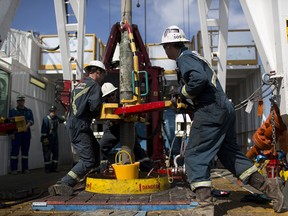 Employees torque a pipe at a wedge well in Alberta. The oil and gas sector helped drive GDP gains in May.