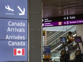 A sign pointing to domestic arrivals at Terminal 1 at Toronto Pearson International Airport.