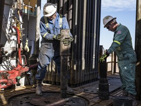 Precision Drilling Corp. oil rig operators install a bit guide on the floor of a Royal Dutch Shell PLC oil rig near Mentone, Texas, U.S.